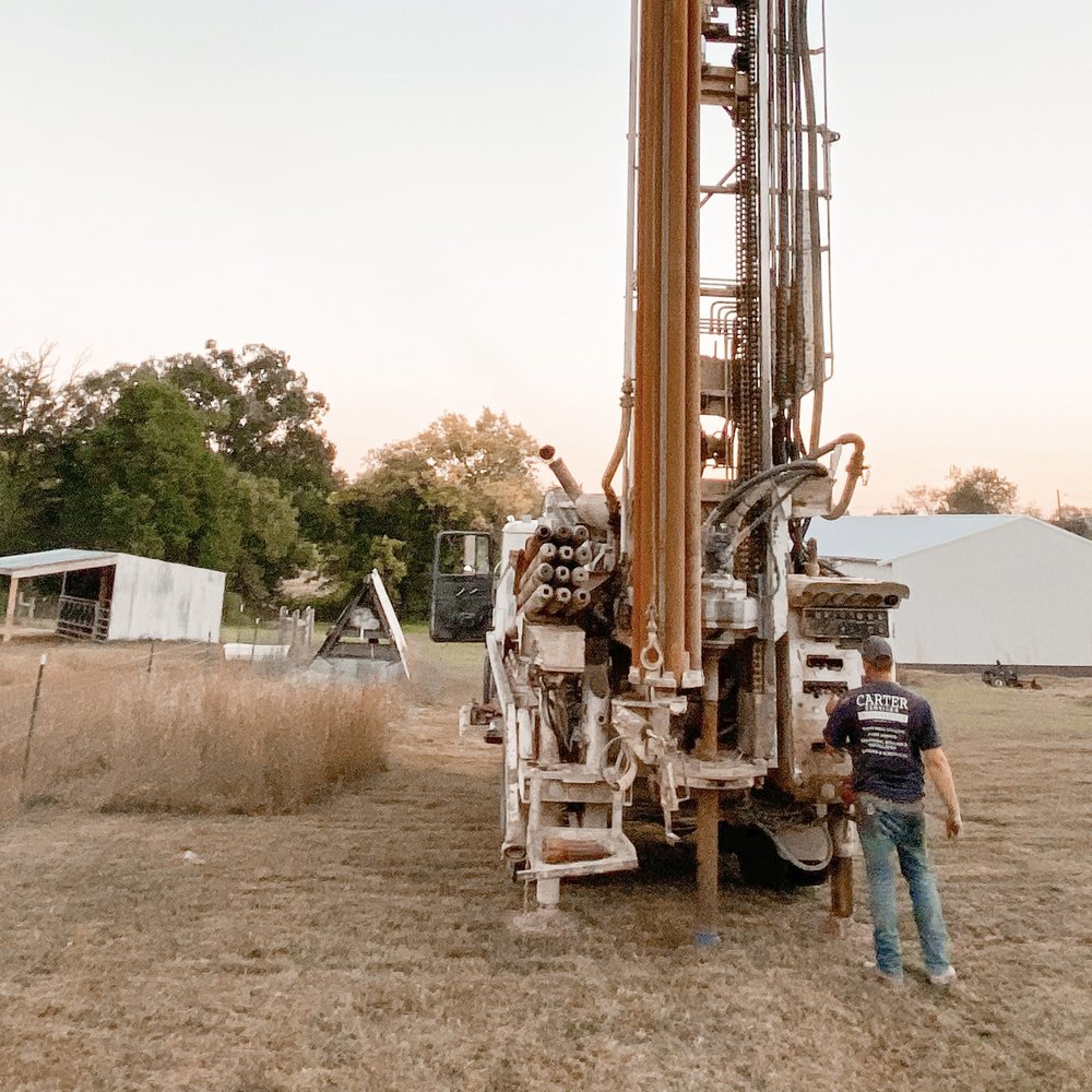 Water well drilling rig operating in Camden garden